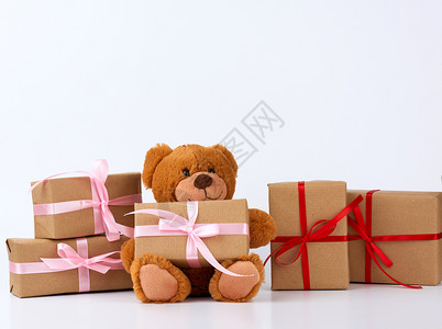 棕色泰迪熊包着棕纸的盒子里装满礼物带丝捆绑生日快乐和情人节图片