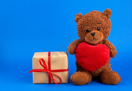 棕色可爱泰迪熊和包着棕色生态纸的盒装礼物图片
