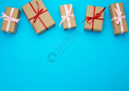 包着棕纸绑红弓蓝色背景的礼物文字位置图片
