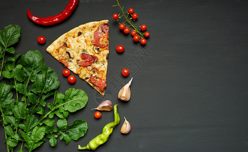 烤披萨三角饼片配蘑菇香肠西红柿和奶酪黑色背景平地复制空间图片