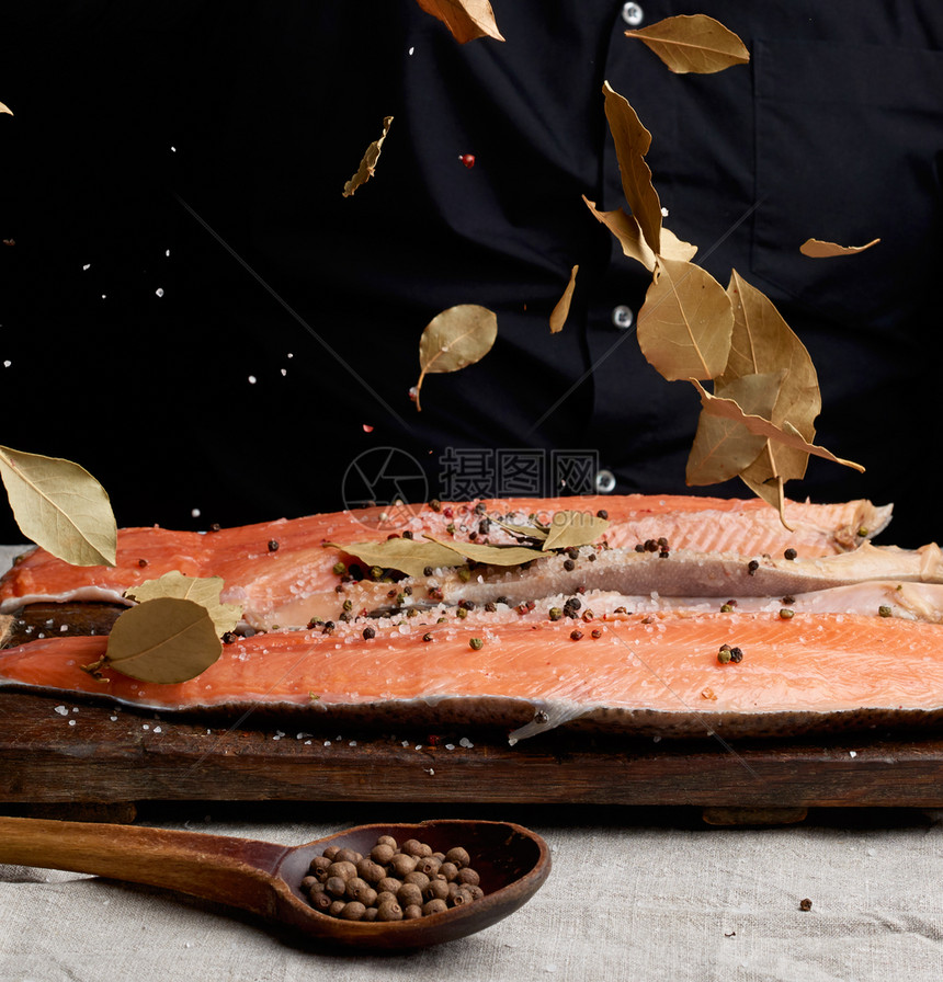 无头鲑鱼排在木板上洒满了干叶子的木板上烧鱼过程图片