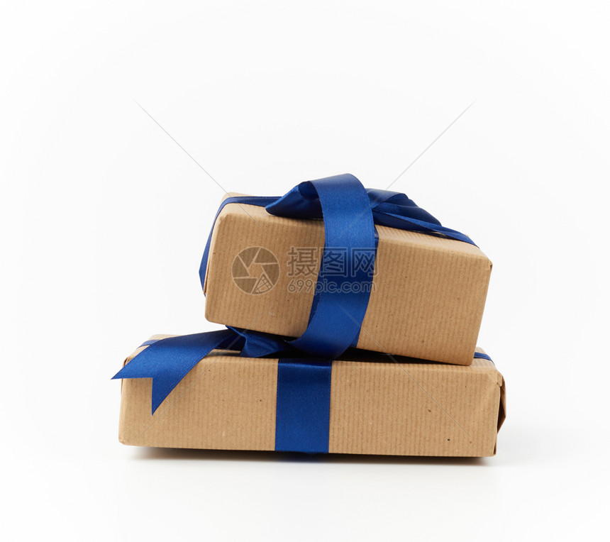 以棕色克拉夫纸包着的矩形盒用丝蓝带捆绑礼物在白色背景上被孤立图片