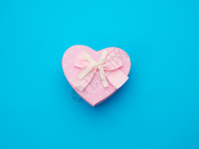 粉红礼物盒以心脏的形式蓝底顶视图喜庆背景的弓形心背景图片