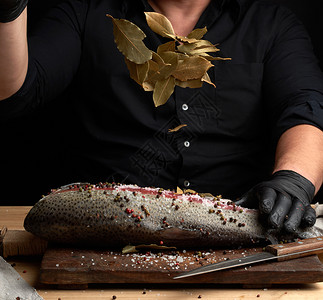 无头鲑鱼排在木板上洒满了干叶子的木板上烧鱼过程图片