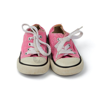 一双粉红色的儿童纺织运动鞋白色鞋带白色背景旧鞋图片