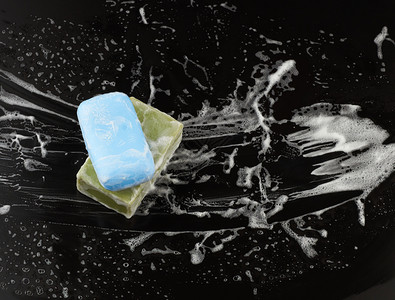 黑底白肥皂泡沫和黑底顶视清洁概念抗菌剂图片