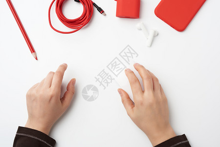 白桌顶视图自由职业者工作场所白无线鼠标红色智能手机和耳图片