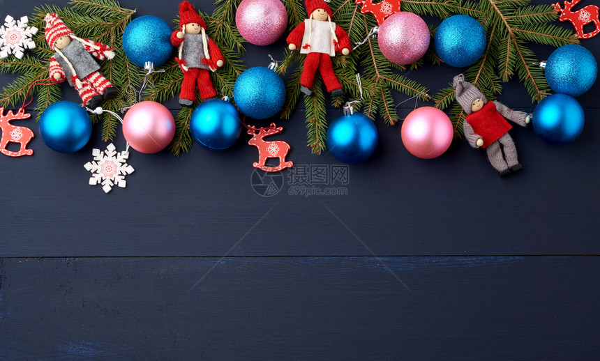 绿色树枝圣诞蓝球和粉红木板上蓝背景的雕装饰复制空间图片