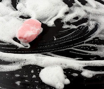 黑底顶视清洁概念抗菌闭合的白肥皂泡沫和粉色图片