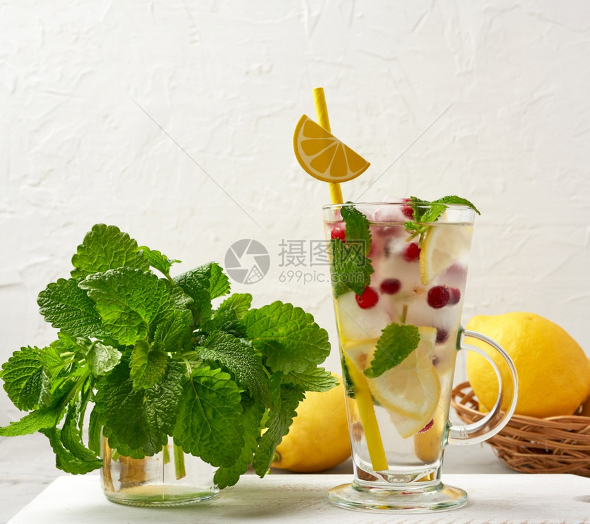 装有柠檬水和冰块红浆果纸管的透明玻璃清凉的夏季饮料图片