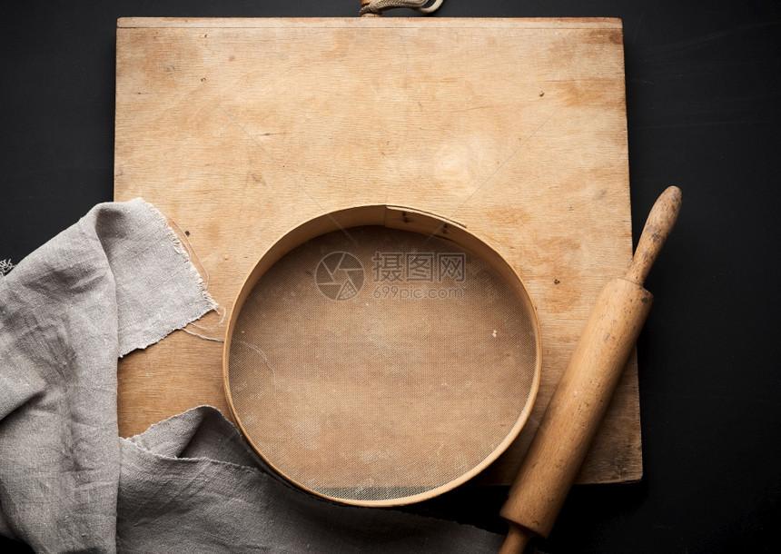古老的木制滚动针和圆锯子灰色纸巾黑桌顶台制作面粉的烹饪用具图片