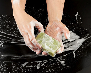 用肥皂洗手过程用黑色背景顶视卫生概念用白泡沫洗手身体部分图片