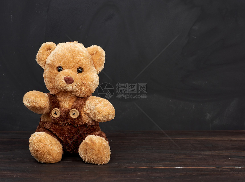 棕褐色泰迪熊坐在棕木桌上坐在空黑粉笔板后面作一个刻字的地方回到学校图片