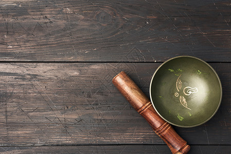 藏歌唱铜碗棕色木制桌上有棍冥想用物和替代药顶视复制空间图片