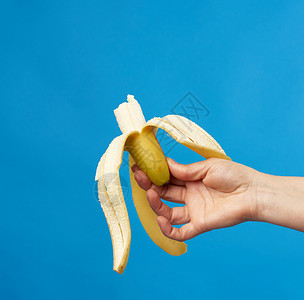 女用手握着蓝底的成熟香蕉皮紧闭图片
