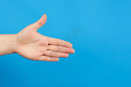 伸出人的手张开身体的一部分在蓝色背景上关图片