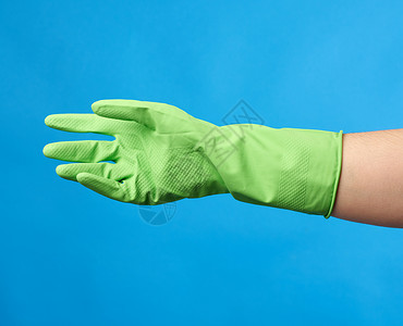 绿色橡胶手套用于清洗身着蓝底女手衣图片