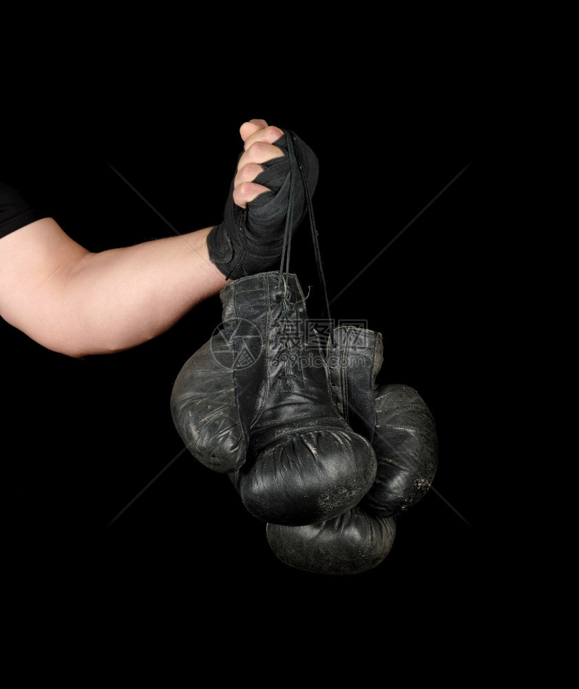 男用黑色弹运动绷带包着男手臂有两对旧式的皮衣拳击手套黑色背景复制空间图片