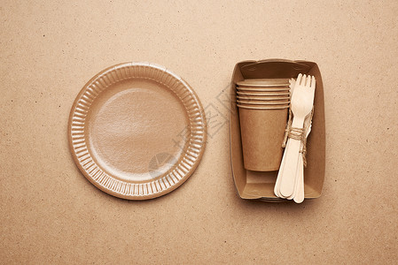 棕色手工艺纸和木叉棕色背景上的刀叉纸板和杯子图片