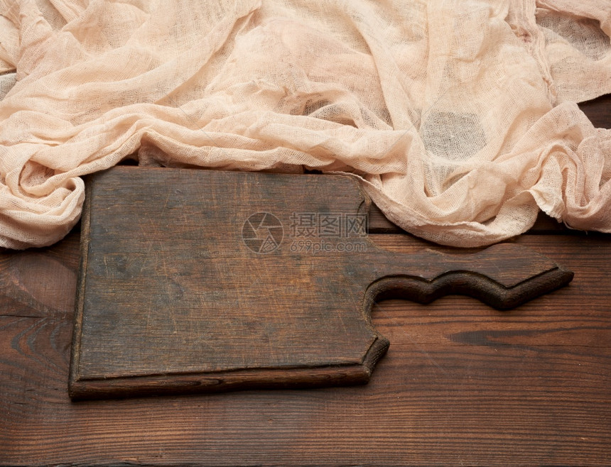 旧棕色木制厨房剪板餐桌上有把手和纱布图片