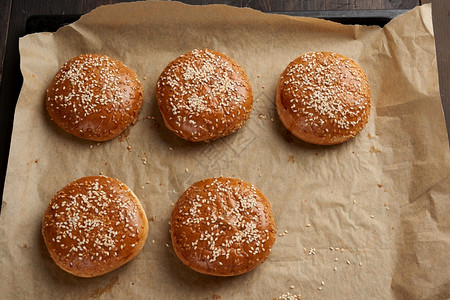 小圆面包棕色纸上烤的芝麻面包汉堡的配料顶视线背景