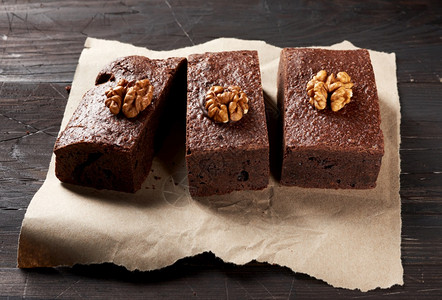 烤巧克力蛋糕棕色纸上有坚果最美景味甜点图片