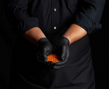 黑乳胶的厨师手套将生扁豆握在手掌上紧闭图片