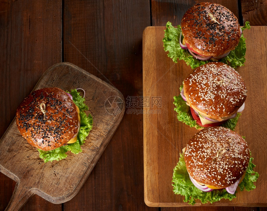 美味的汉堡和芝麻面包在古年棕色切面板上最美的景色木桌图片