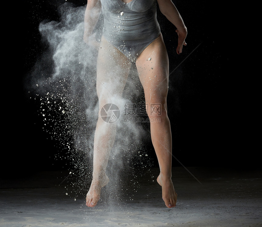 跳着舞运动员的腿白面粉尘云黑色背景穿体衣的女人图片