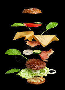 起司汉堡成份多汁肉菜干酪奶芝麻面包生菜白洋葱环番茄片黑底黄瓜图片
