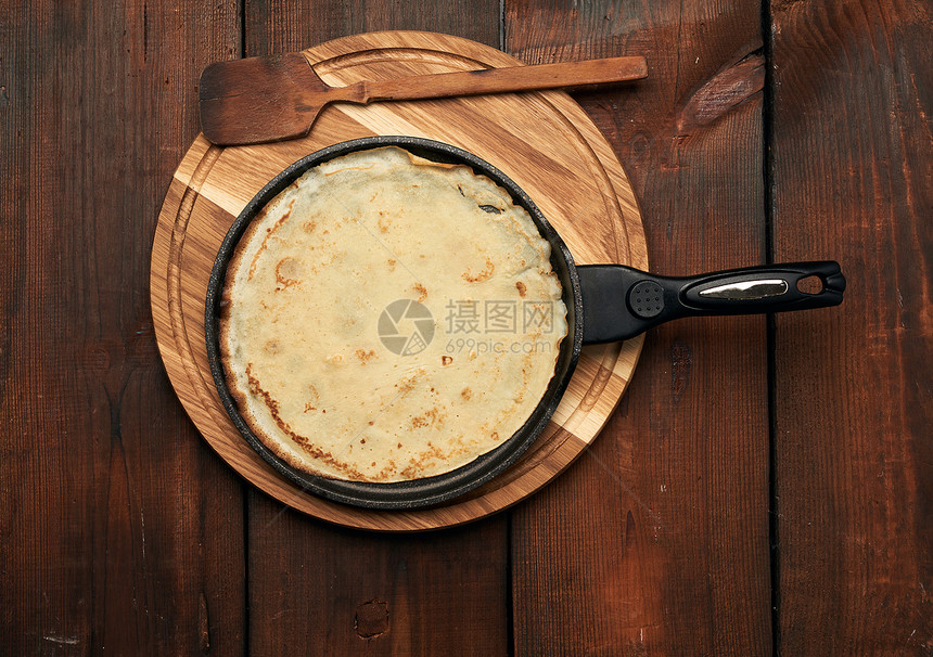 在棕色木制桌子上的黑煎锅里烤圆大饼最佳景色嘉年华图片