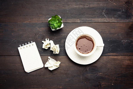棕色木制桌顶视图上黑咖啡白陶瓷杯图片