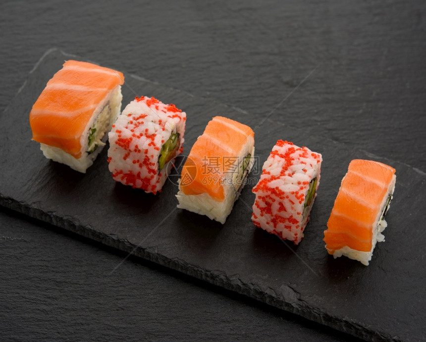 在黑板上顶层风景黑板上有红鱼子酱的寿司和几片花生图片