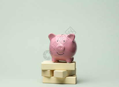 灰色背景的粉瓷小猪银行增加账户储蓄收入的概念图片