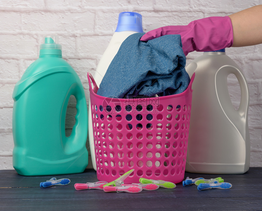 用粉色手套把东西放在塑料洗衣篮里图片