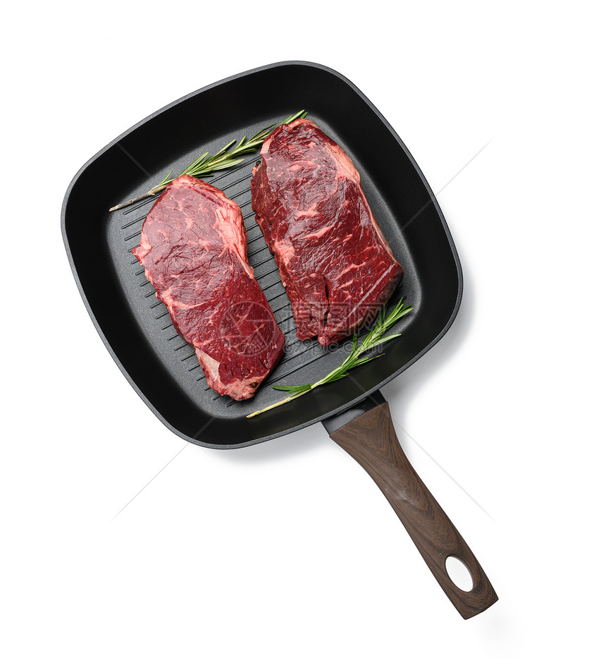 两块生牛肉在黑方烧烤锅里排在白色背景的牛排图片