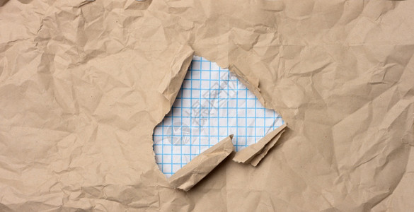 棕色克拉叶纸有洞撕裂的边缘中间是白方纸背景图片