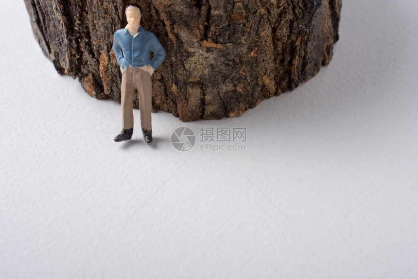 在树干旁做模特的男小雕像图片