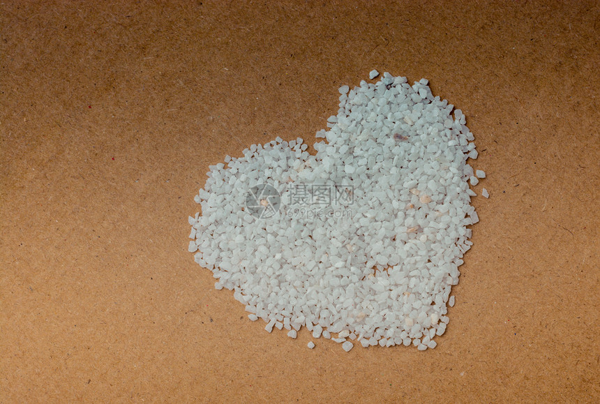 白沙石在棕色背景上形成心脏状图片
