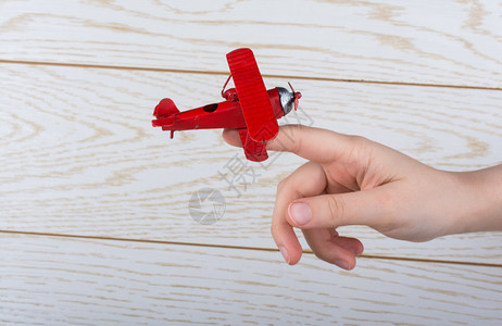 手持红色玩具飞机背景图片