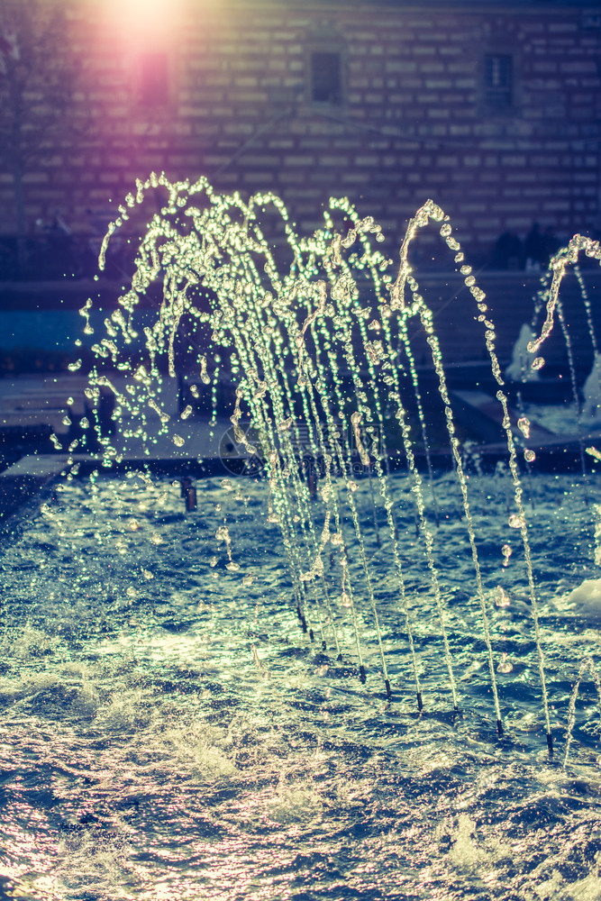 喷泉在公园的游泳池里喷出闪光的水图片