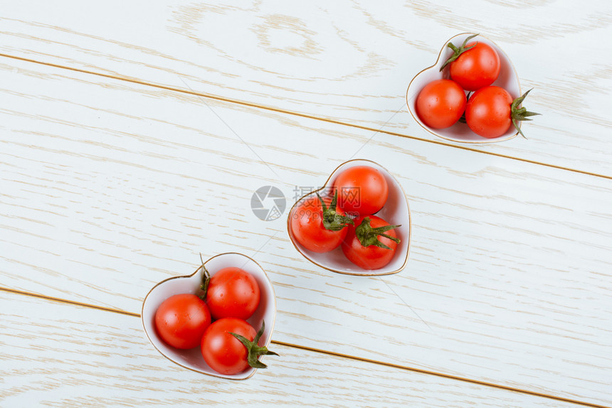 红熟樱桃番茄在心形碗中的番茄图片