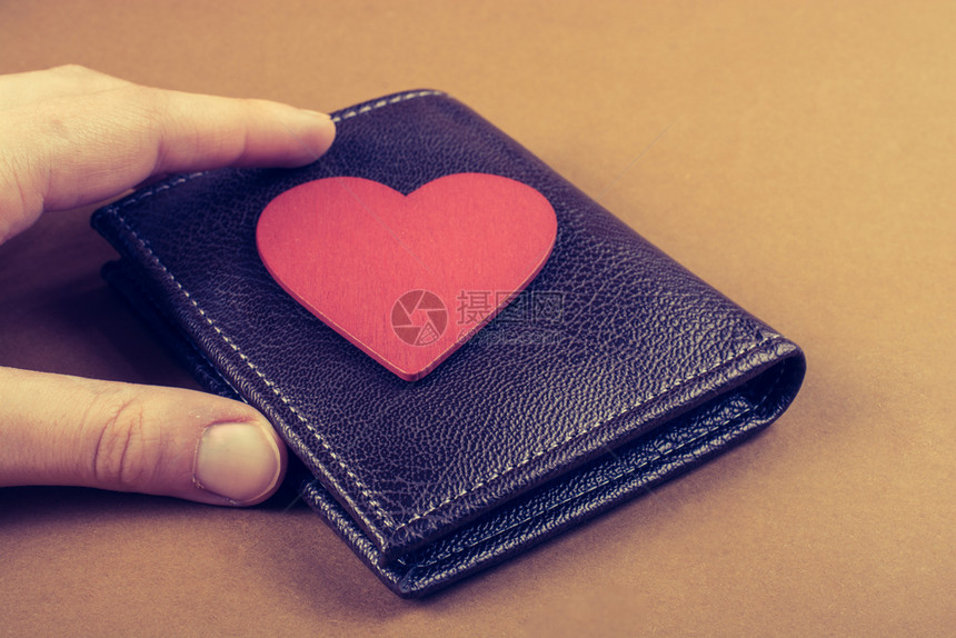 心形和钱包作为财务概念手头的心形和钱包图片