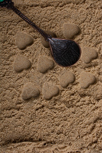 茶匙旁的沙面上红心形状图片