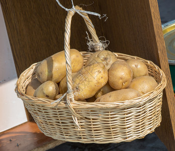 生菜背景的篮子里土豆图片
