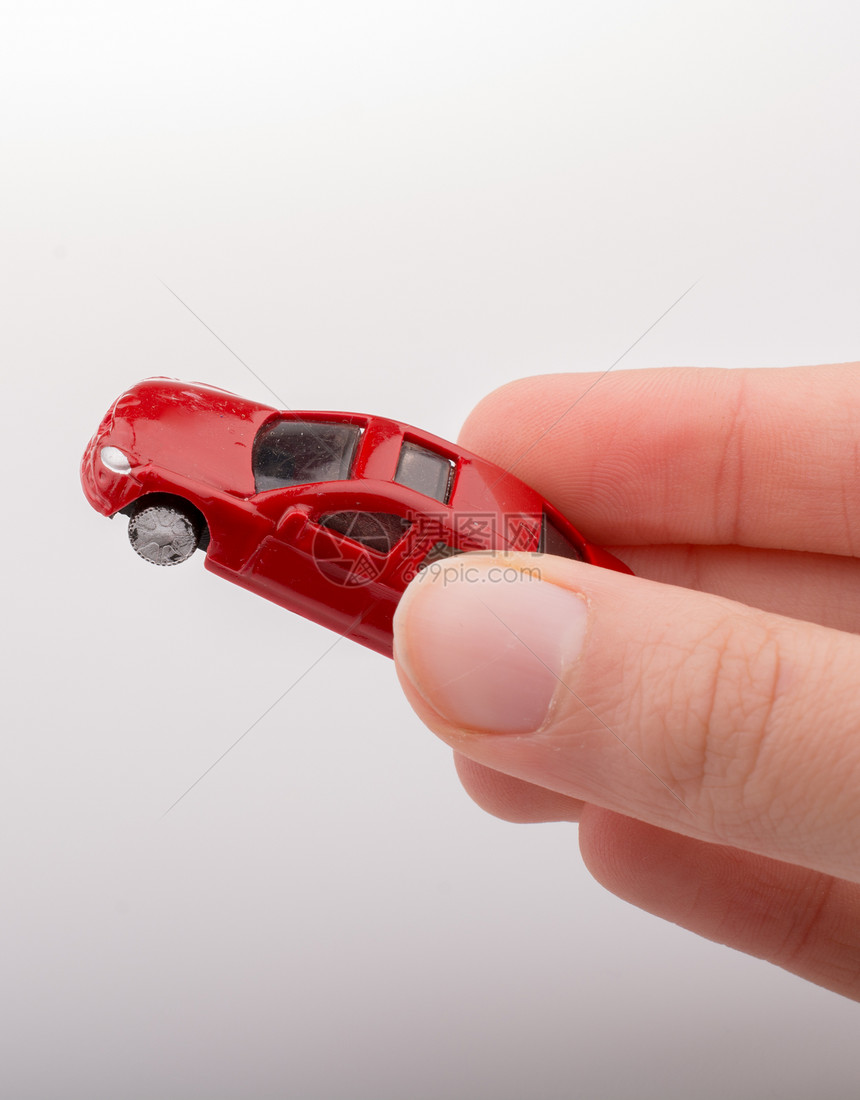 白色背景上手握着多彩的小玩具车图片
