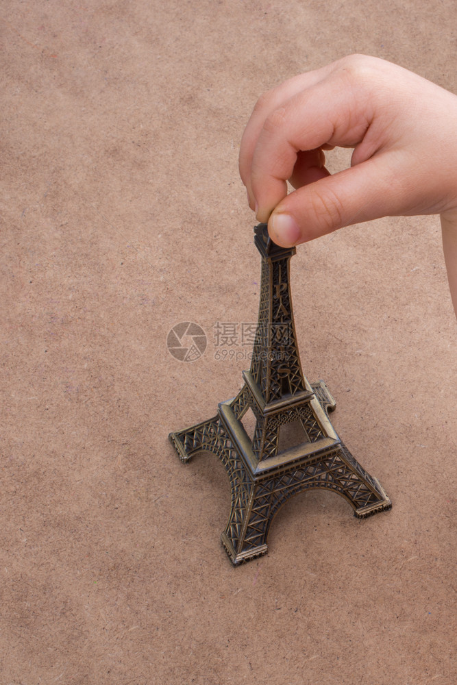 孩子手握着艾菲尔铁塔的小模型图片