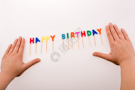 手和蜡烛在棍上彩色蜡烛写着生日快乐图片