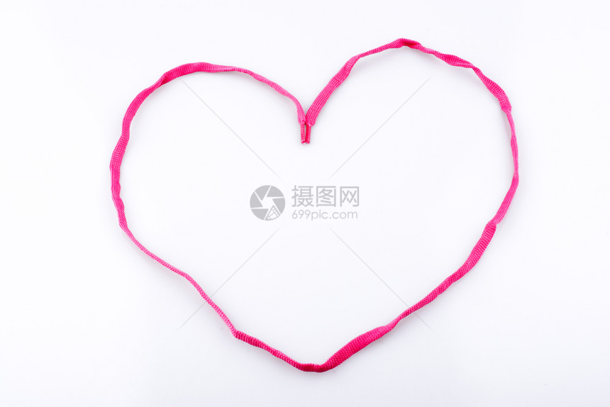 由白色背景的粉红护罩所帮助形成的心图片
