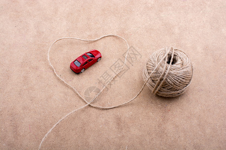 TRed玩具车和一串线条在背景上形成心脏状图片
